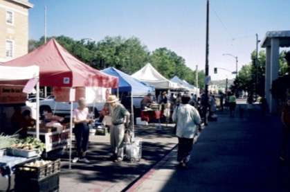 Customers shopping at vendors' tents lining Cortez Street